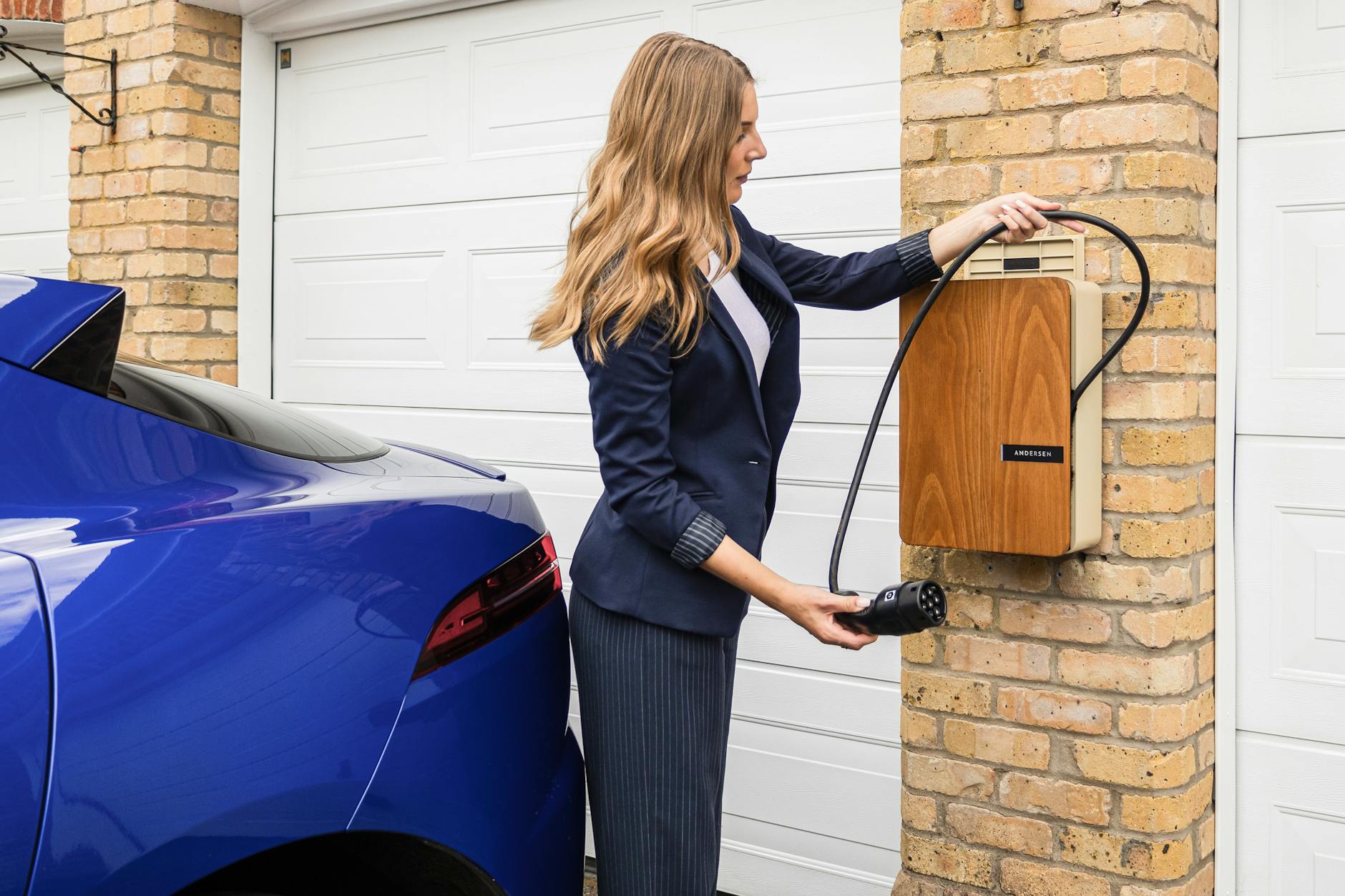 Kobieta ładująca elektryczne auto BYD z domowej ładowarki wallbox Kobieta ładująca elektryczne auto BYD z domowej ładowarki wallbox