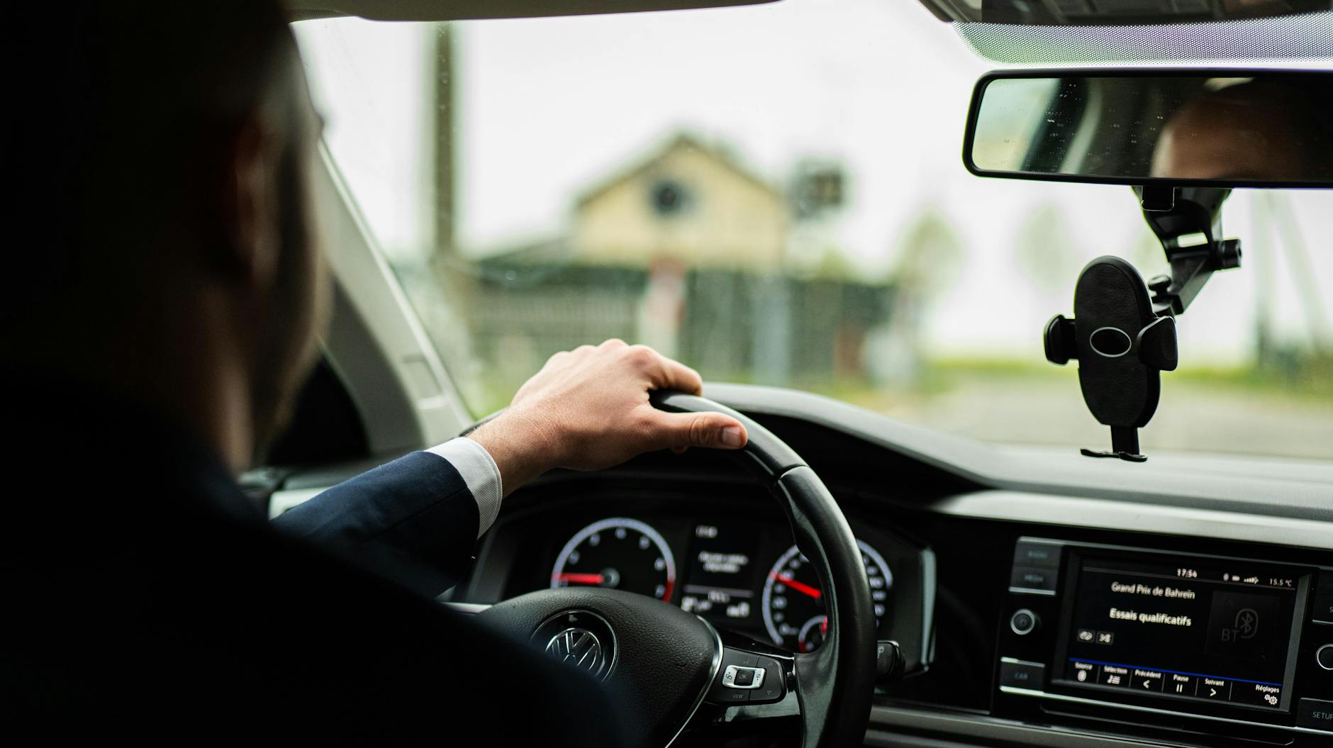 Mężczyzna w garniturze prowadzi Maserati, zbliżenie na kierownicę i deskę