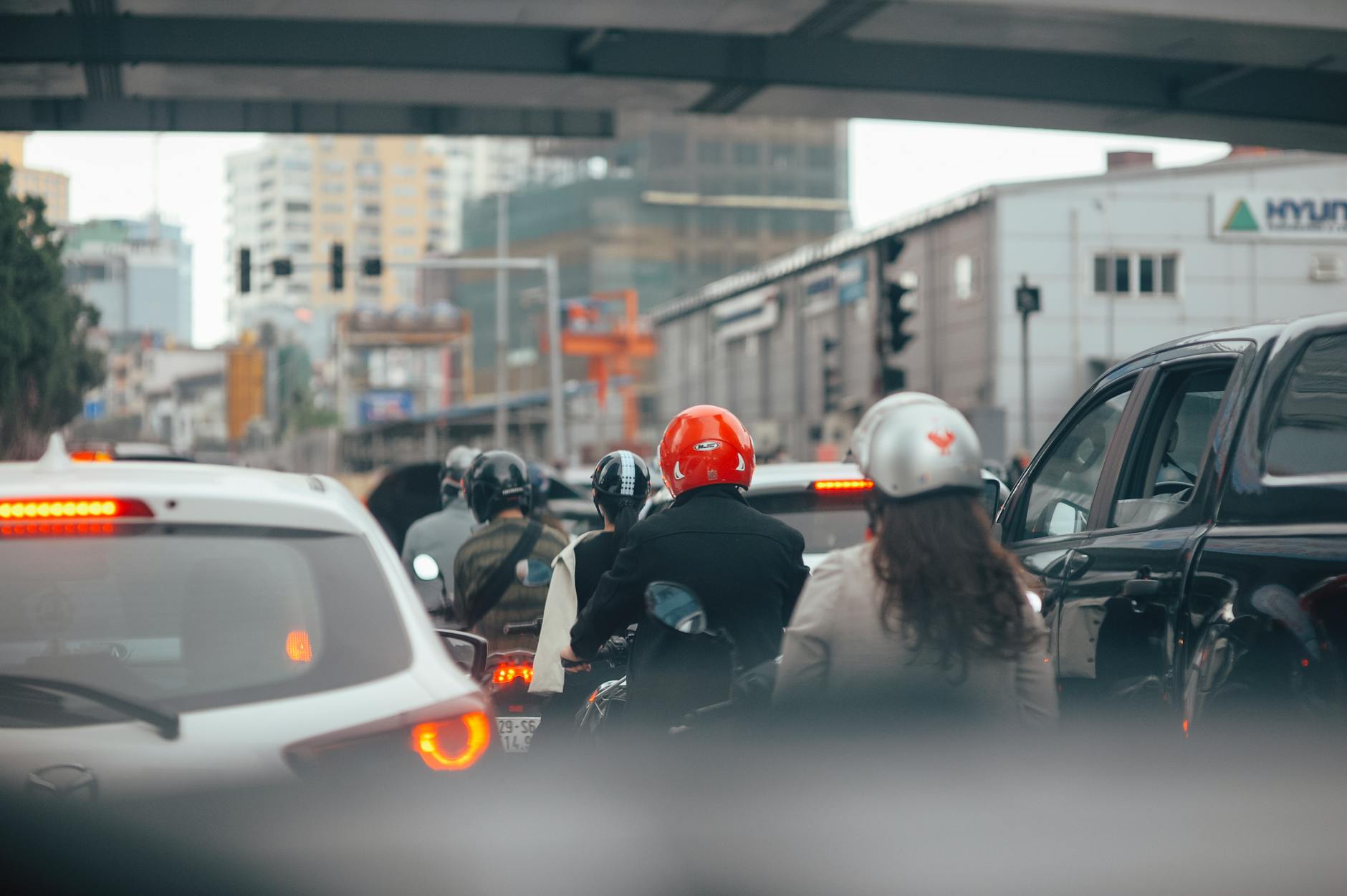 Ruchliwa ulica miasta z samochodami i motocyklistami na światłach