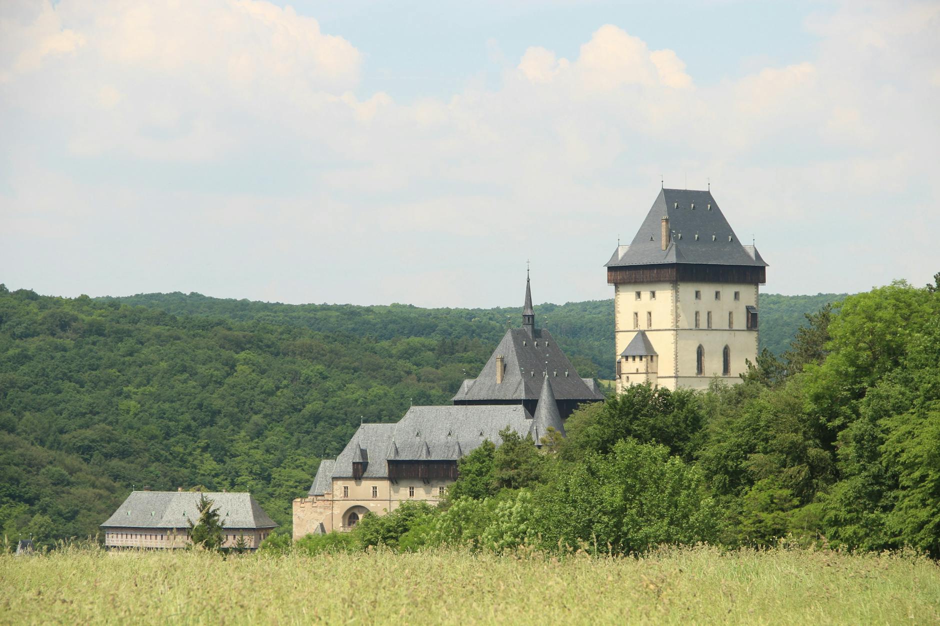 Zamek Karlštejn wśród zielonych wzgórz, widok jak z bajki Zamek Karlštejn wśród zielonych wzgórz, widok jak z bajki