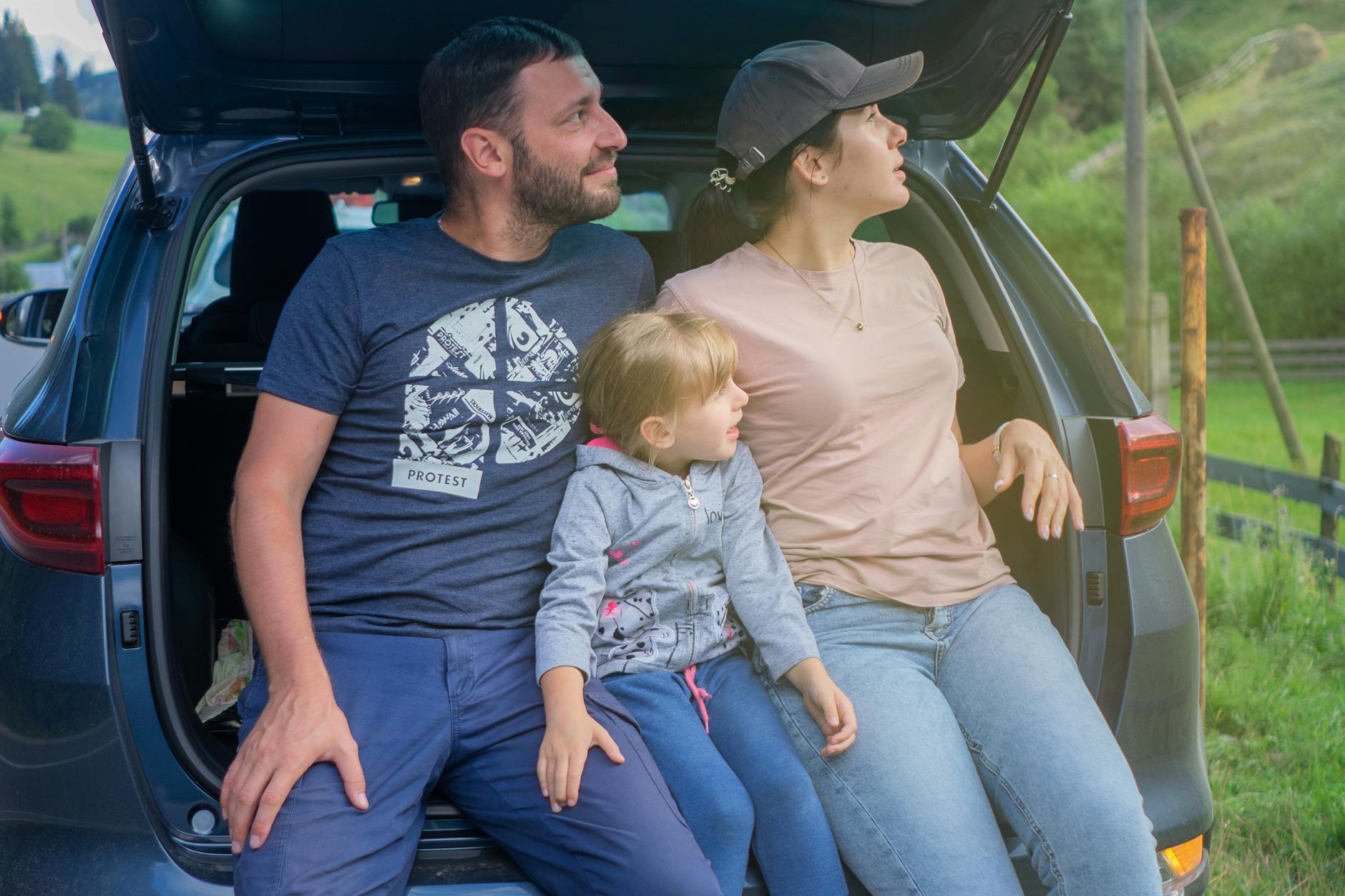 Rodzina siedząca w bagażniku Volvo podczas wakacyjnej wyprawy