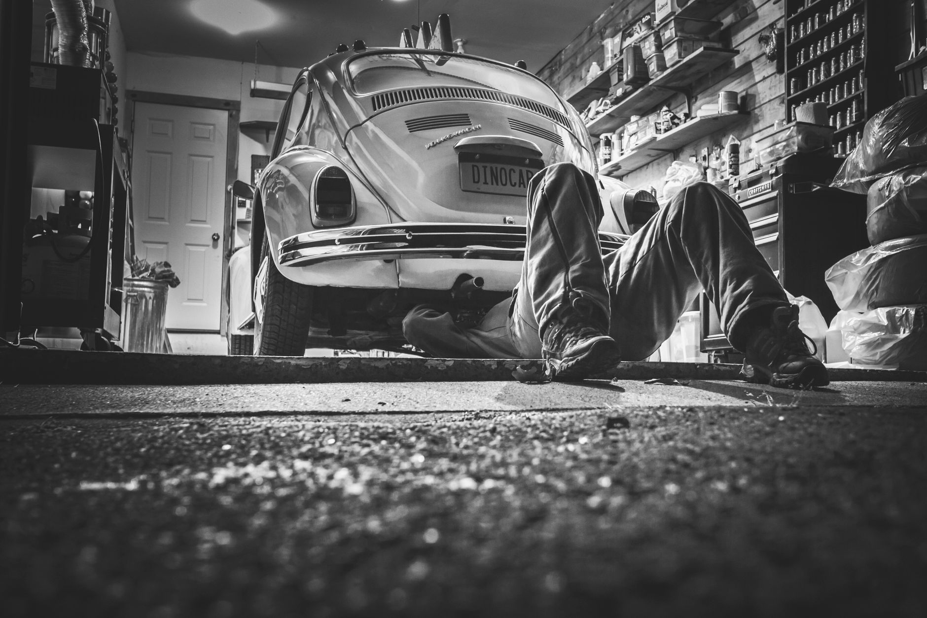 Mechanik naprawia klasyczne auto w starej garażowej pracowni