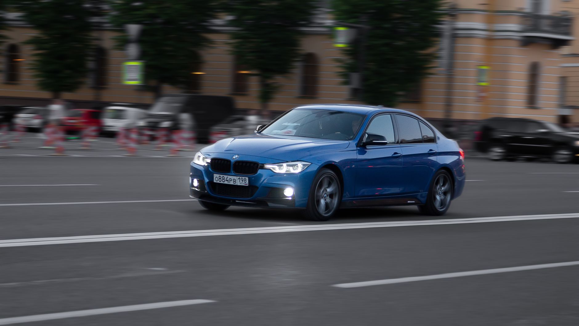 Niebieskie Maserati jedzie z dużą prędkością ulicą w nowoczesnym mieście