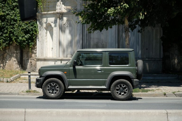 Zielony Suzuki 4x4 zaparkowany na słonecznej miejskiej ulicy